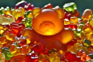 大きなクマのグミとその周りのたくさんのグミ